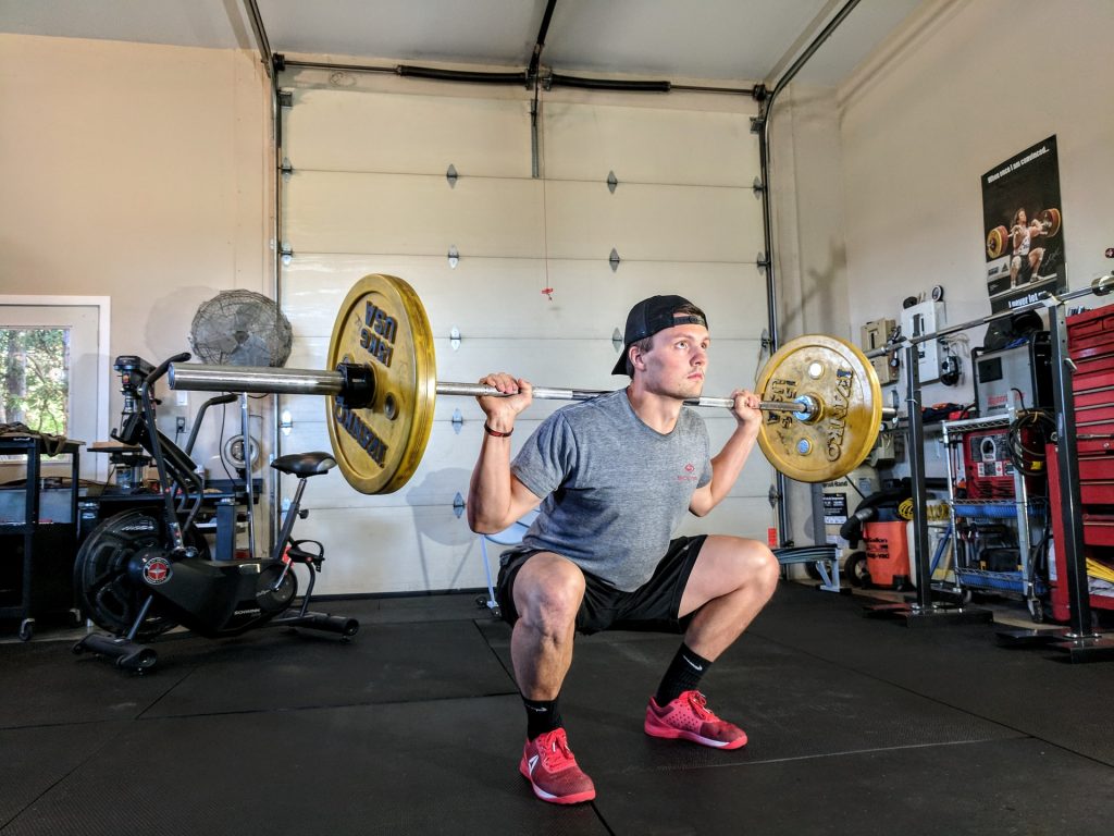 man-lifting-weight-garage-gym